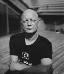 Bald man with black t-shirt looking at camera