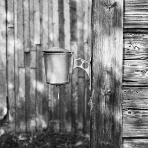 A monochrome image of a metal bucket, showcasing its texture and shape