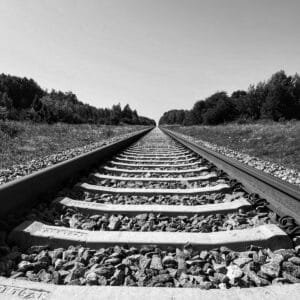 A monochrome image of a railroad track stretching into the distance