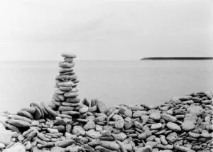 A monochrome image of a pile of stones on a stony beach