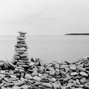 A monochrome image of a pile of stones on a stony beach