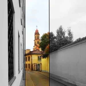 Narrow street picture with a church tower in the background