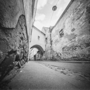 An atmospheric black and white picture showcasing a charming alleyway in Vilnius Old Town