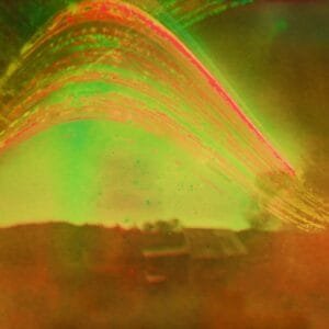 A vibrant green and red photo. The sun's path adds a touch of seasonal beauty.