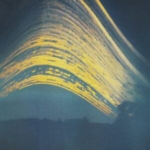 Long exposure captures wave's motion under sun path in blue