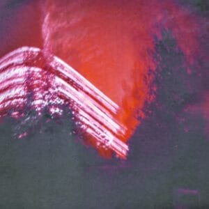 A vibrant red and purple building captured in a photo, standing out against the backdrop of the sun's path over six months